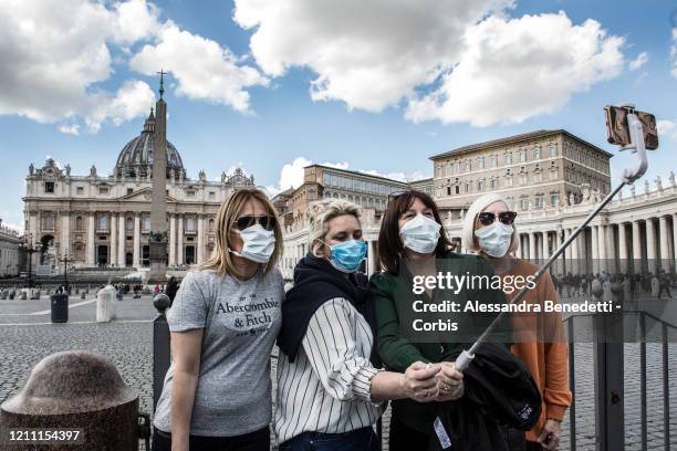 Tourists wearing protective masks take a selfie on March 08, 2020 in St. Peter's Square at the Vatican, Italy. Italian government has placed nearly a...