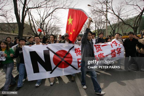 Demonstrators carrying Chinese flags and anti-Japanese banners shout as they march in Beijing to protest Japan's handling of its wartime past and...