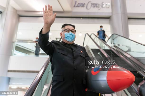 An impersonator of North Korean Leader Kim Jong Un makes a gesture during a protest at the International Finance Center shopping mall on April 28,...