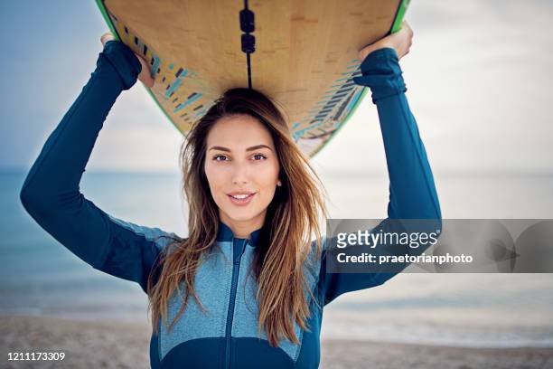 retrato de mujer surfista de pie en la playa - neoprene fotografías e imágenes de stock