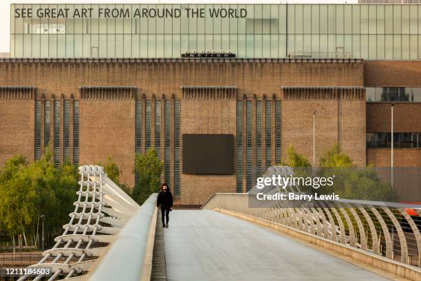 Woman in mask in front of the Tate Modern Gallery taken on the Millenium Bridge during the coronavirus pandemic on the 24th April 2020 in London,...