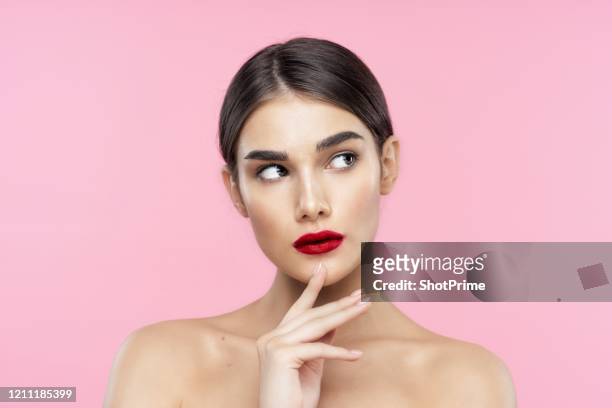 beauty portrait of a young woman with a highlighter on her skin and body with a thin and long neck, shiny skin on her face, big eyes, spa treatments, beauty blog, cosmetology, pensive look - eyebrow stock-fotos und bilder