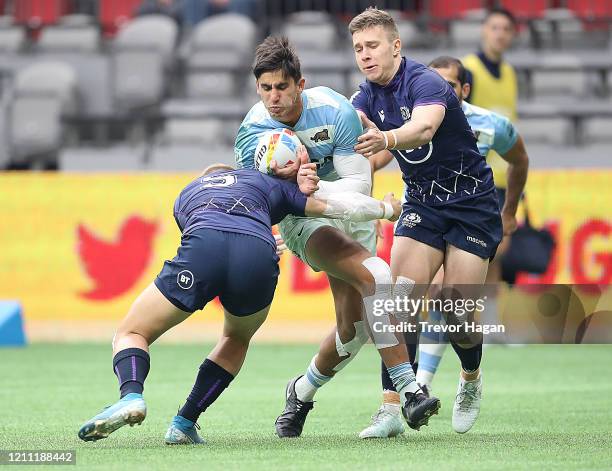 Harvey Elms and Kyle Rowe of Scotland tackle Lucio Cinti of Argentina during their sevens rugby match at BC Place on March 08, 2020 in Vancouver,...