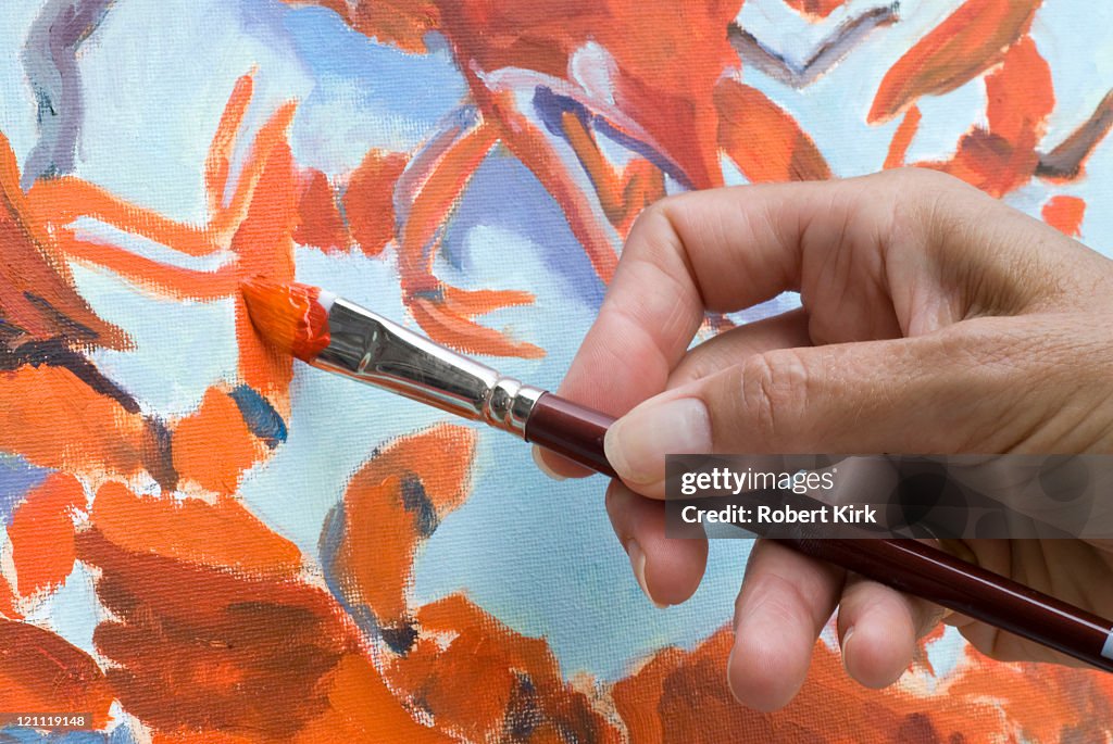 Artist applying paint to canvas