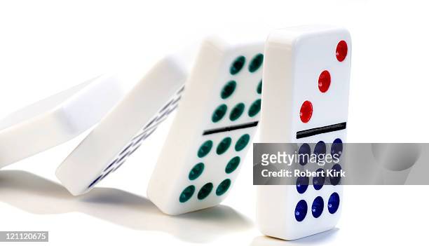 dominoes falling against each other on a white background - dominos falling stock pictures, royalty-free photos & images