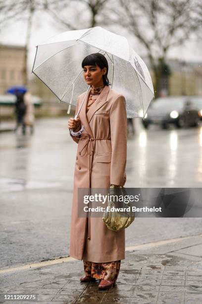 Maria Bernad wears a pink long coat, a Bottega Veneta cream color puff bag, a turtleneck brown dress, during Paris Fashion Week - Womenswear...