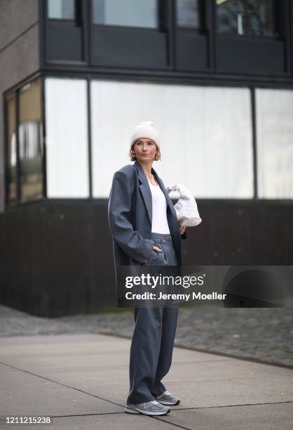 Kathrin Bommann wearing Frankie Shop suit, The Sept top, Bottega Veneta bag, New Balance sneaker and by Aylin König beanie on March 07, 2020 in...