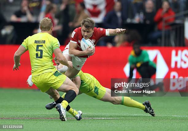 Lachie Miller and Henry Hutchison of Australia tackle Theo Sauder of Canada during their rugby sevens semi final at BC Place on March 08, 2020 in...