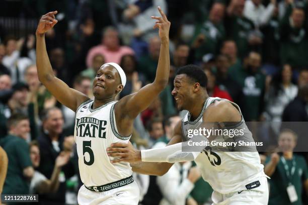 Cassius Winston of the Michigan State Spartans celebrates a second half three pointer with Xavier Tillman Sr. #23 while playing the Ohio State...