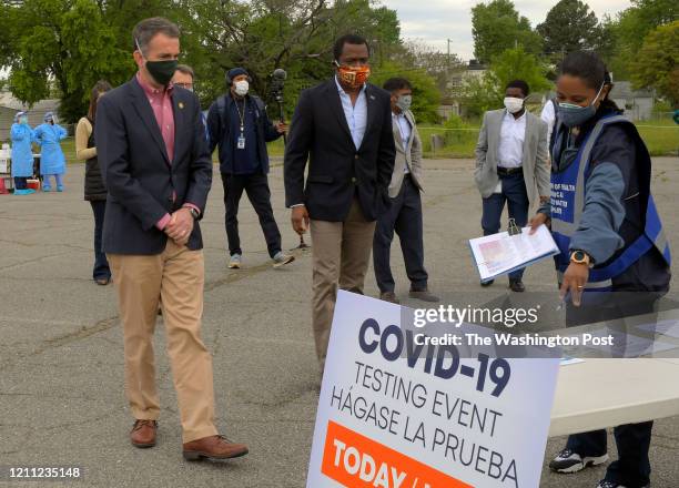 Virginia Governor Ralph Northam wearing a mask, left, and Richmond Mayor Levar Stoney, center, also wearing a mask, were on hand to watch the set up...