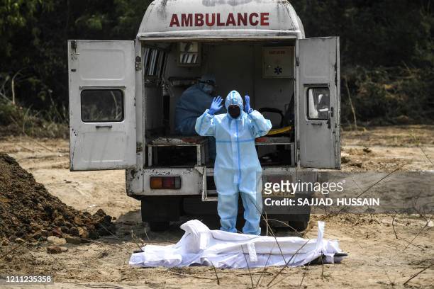 Muslim man in protective gear offers funeral prayers for a Central Reserve Police Force personnel who died from the COVID-19 coronavirus before his...