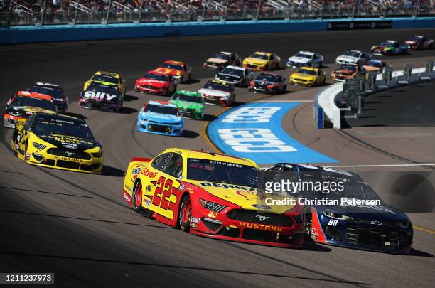 Joey Logano, driver of the Shell Pennzoil Ford, and Alex Bowman, driver of the Axalta Chevrolet, lead during the NASCAR Cup Series FanShield 500 at...