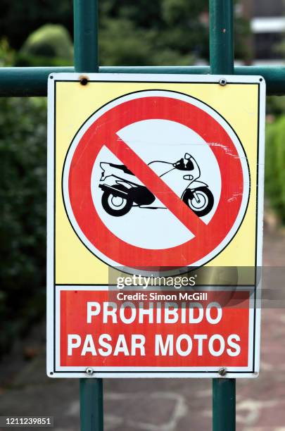 'prohibido pasar motos' (motorbikes prohibited) sign on a fence - do not enter sign stock-fotos und bilder