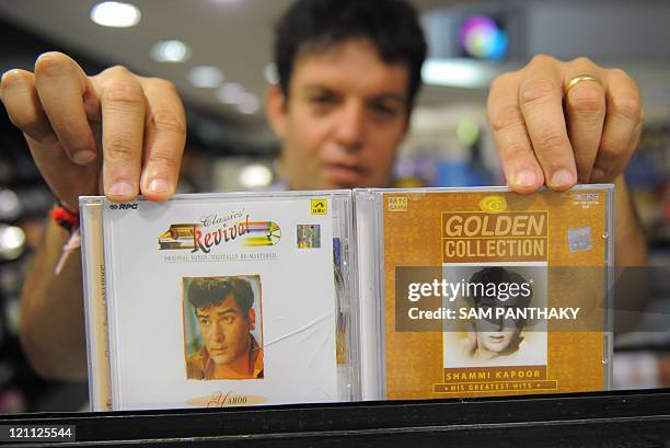 An Indian sales person displays CD's of Bollywood actor Shammi Kapoor at a store in Ahmedabad on August 14, 2011. Legendary Bollywood heart-throb...