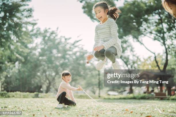 young family jumping ropes joyfully on the lawn - asian jump rope stock pictures, royalty-free photos & images