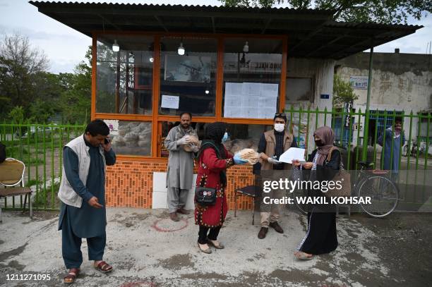 Woman receives free bread from the municipality outside a bakery during the Islamic holy month of Ramadan as government-imposed a nationwide lockdown...