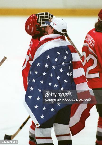Captain Karyn Bye draped in the Stars and Stripes shakes hands with the Canadian team after the Olympic women's hockey final at the Big Hat in Nagano...