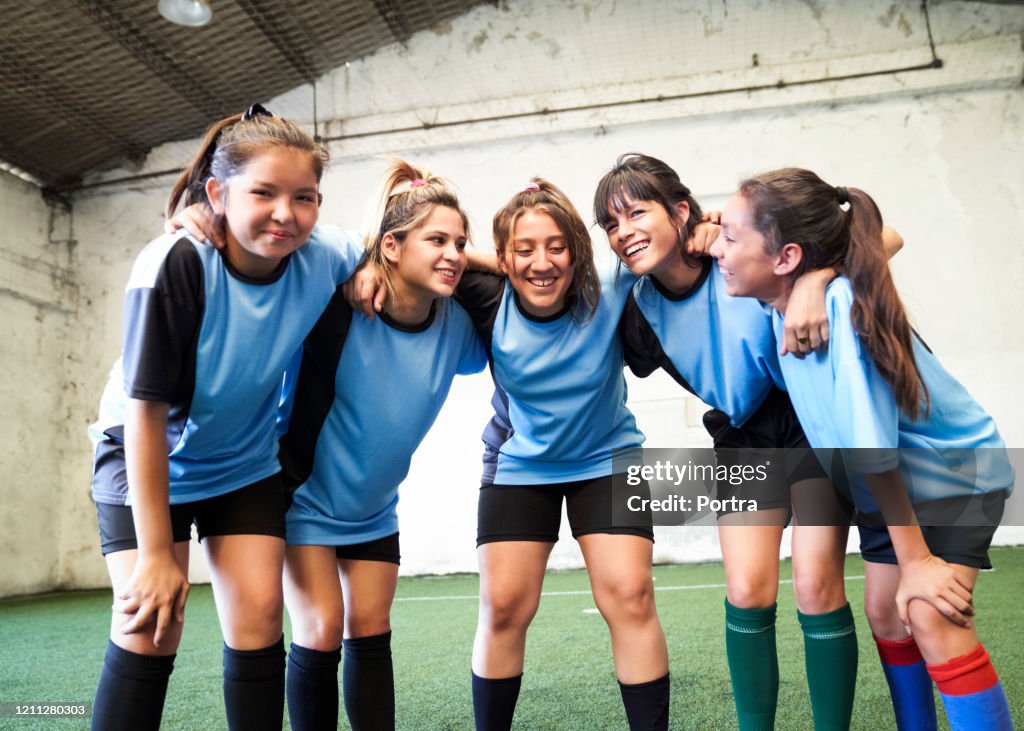 Time de futebol feminino se amontoando após vencer partida