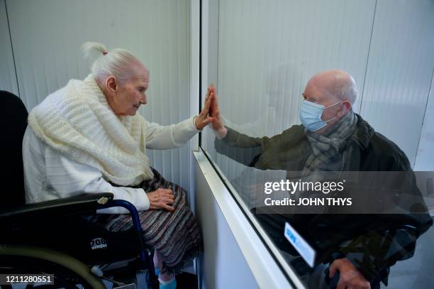 Suzanne Valette infected with COVID-19, meets with her son Philippe Melard through a plexiglass lock inside the contenair at the Buissonets...