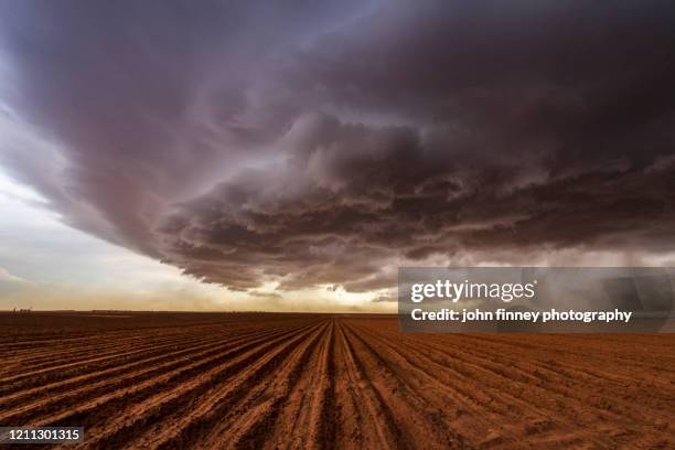 supercell thunderstorm over a drought cracked earth, texas. - moody sky stock pictures, royalty-free photos & images