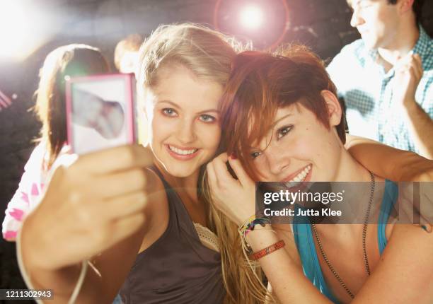 happy teenage girl friends taking selfie with smart phone at party - teenage girl club stock-fotos und bilder