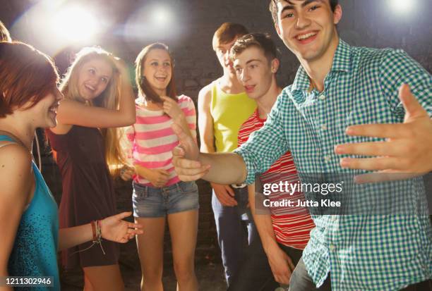 happy teenage friends dancing at party - boy party photos et images de collection