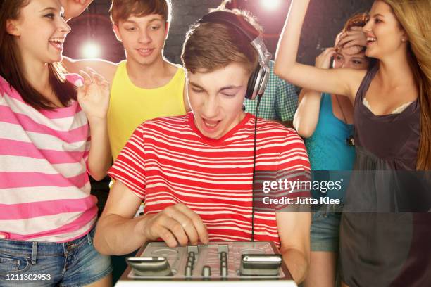 teenage boy dj playing music for friends dancing at party - girl dj stock-fotos und bilder