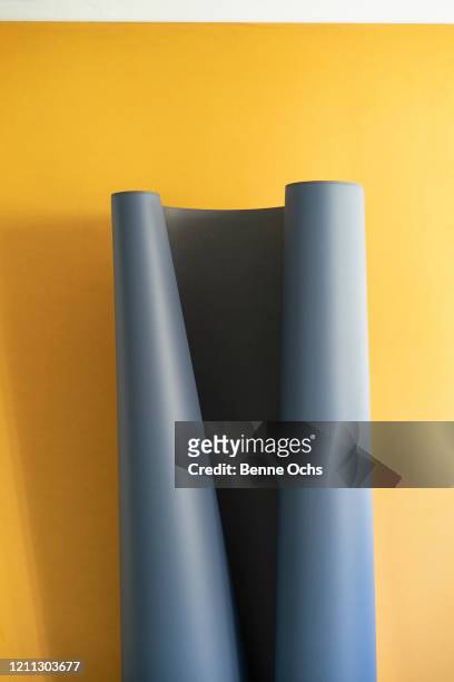 gray sheet unrolling on yellow background - roll stock pictures, royalty-free photos & images