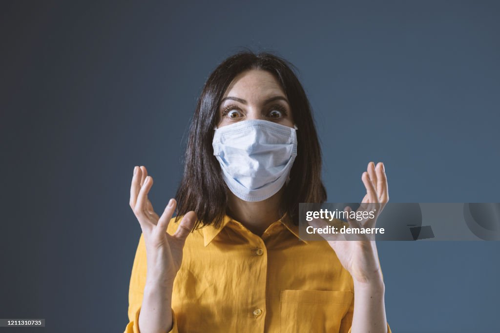 Panische Frau trägt eine Gesichtsmaske gegen covid-19