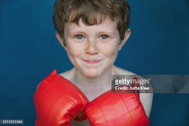 portrait smiling boy with freckles in boxing gloves - red hair boy and freckles stock-fotos und bilder