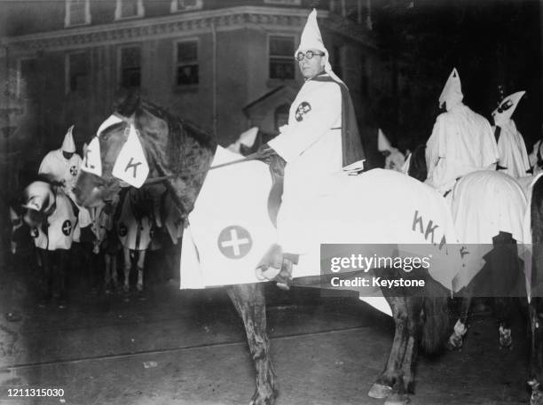 Klansman riding a horse at a parade held at night in Annapolis, Maryland, US, circa 1923.