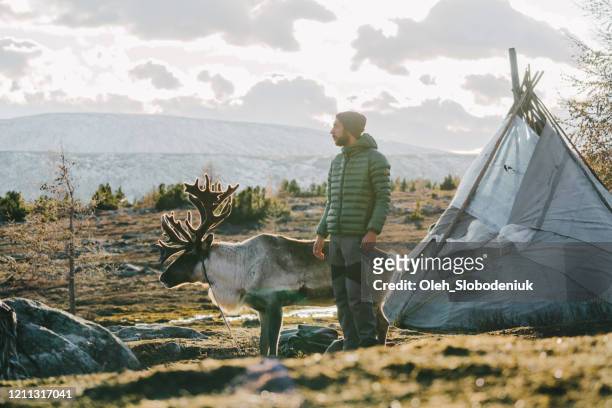 mann mit reder steht im winter in der nähe des tipis in der mongolei - almabtrieb stock-fotos und bilder