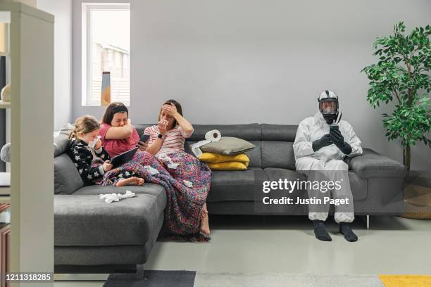 family on sofa. three has the flu. the dad isn't taking any risks! - sneeze stock pictures, royalty-free photos & images