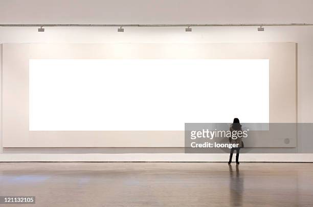 una donna guardando cornice bianca in galleria d'arte - looking at camera foto e immagini stock