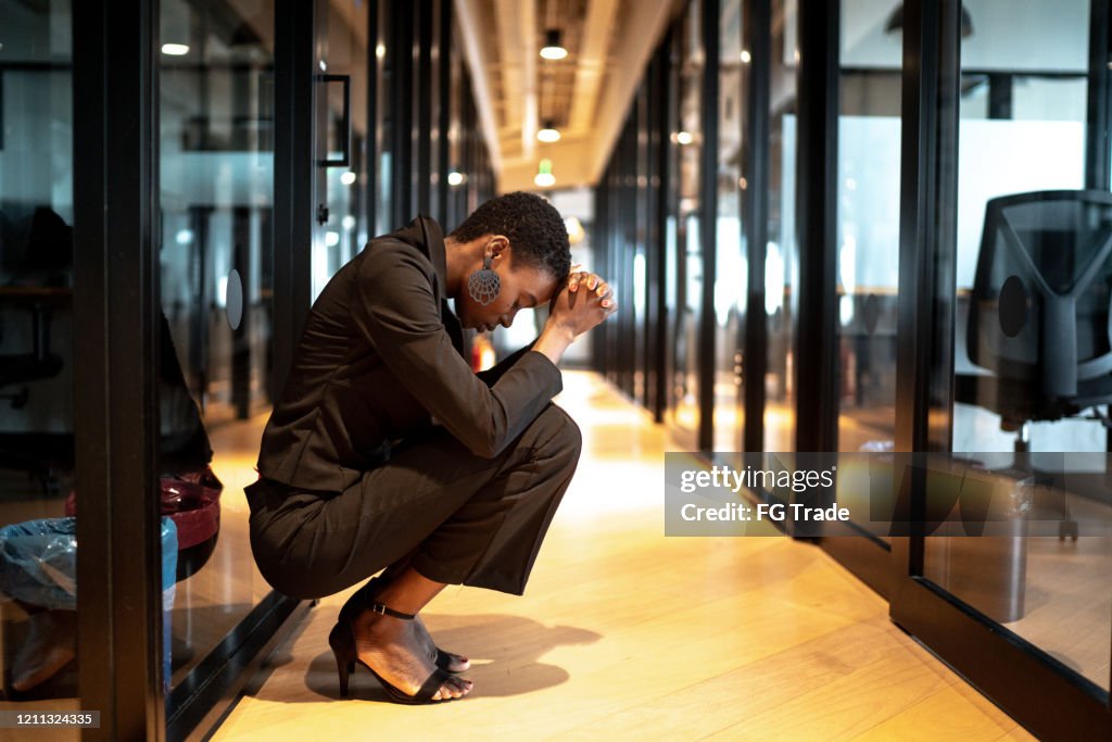 Worried young businesswoman at corridor office