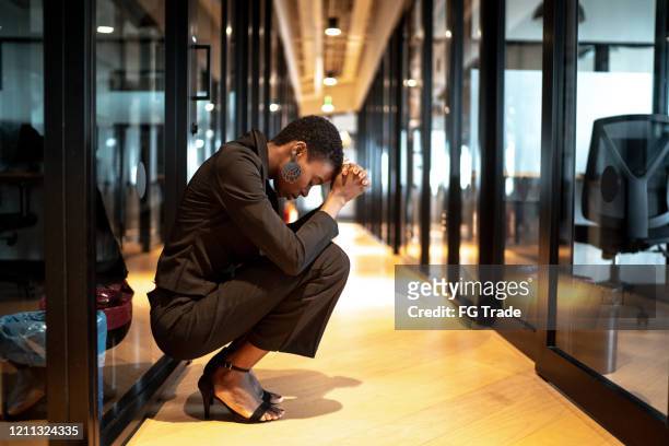 worried young businesswoman at corridor office - depression sadness stock pictures, royalty-free photos & images