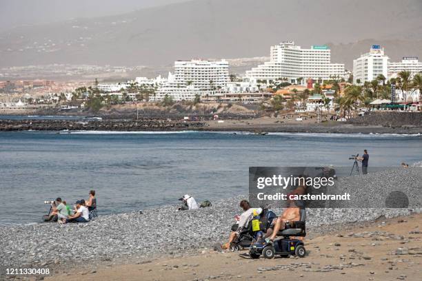 people on a stony beach and a calm sea - white bay stock pictures, royalty-free photos & images