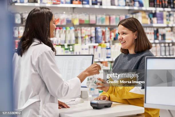 happy woman taking medicine from cashier - pharmacy imagens e fotografias de stock