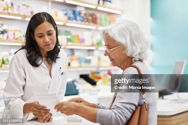 customer showing prescription to female doctor - pharmacist fotografías e imágenes de stock