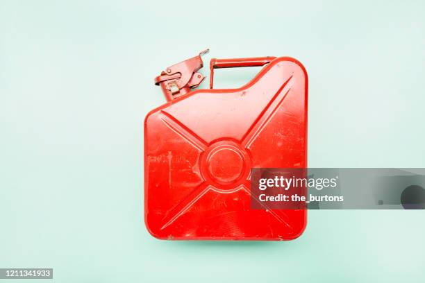 directly above shot of red oil canister on turquoise background - benzinkanister stock-fotos und bilder