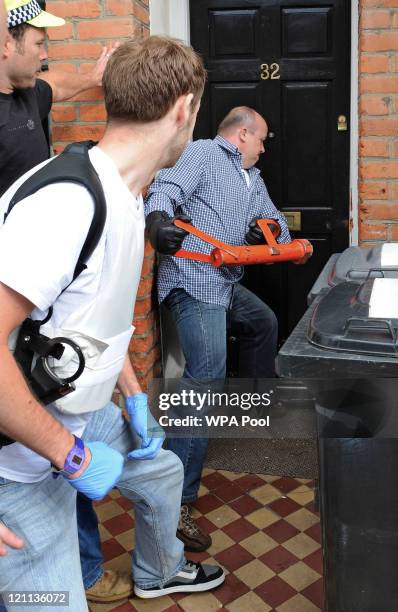 Metropolitan police officers force entry through the front door of a property in Streatham during an early morning raid in connection with recent...