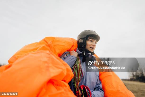 frau trägt ihren fallschirm - paragliding stock-fotos und bilder