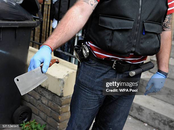 Blade, suspected to be used in connection with recent rioting and looting in the capital, is removed as evidence by a Metropolitan Police officer...