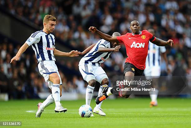 Danny Welbeck of Manchester United is challenged by Youssouf Mulumbu and James Morrison of West Bromwich Albion during the Barclays Premier League...