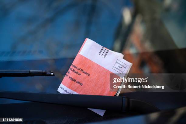 Parking ticket is placed on the windscreen of a vehicle in the Brooklyn n neighborhood of New York City on March 8, 2020. Parking tickets can cost as...