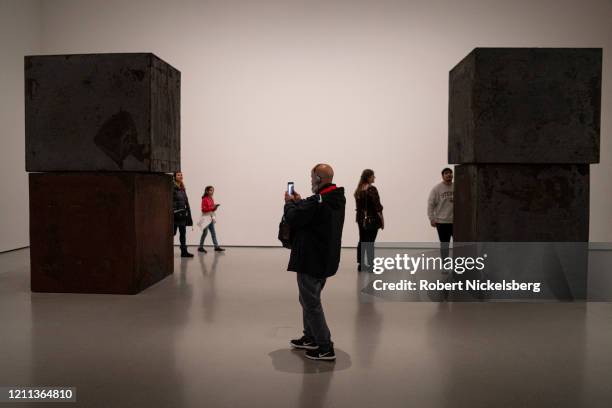 Visitors to the Museum of Modern Art view Richard Serra"u2019s 320-ton sculpture called Equal in New York City on March 7, 2020. The sculpture is...