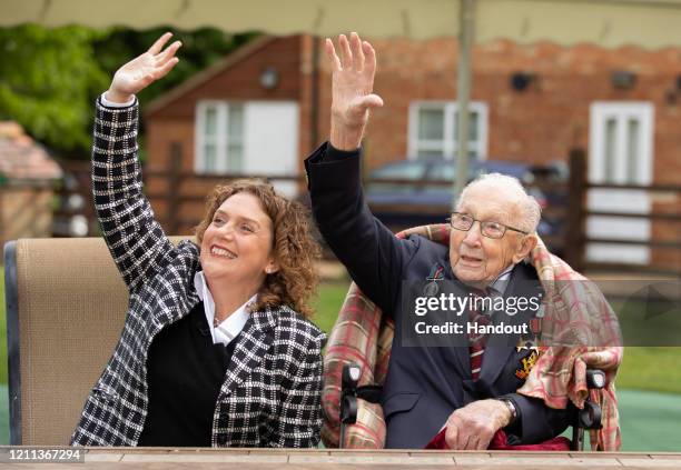 In this handout image provided by Capture the Light Photography, Colonel Tom Moore and his daughter Hannah celebrate his 100th birthday, with an RAF...