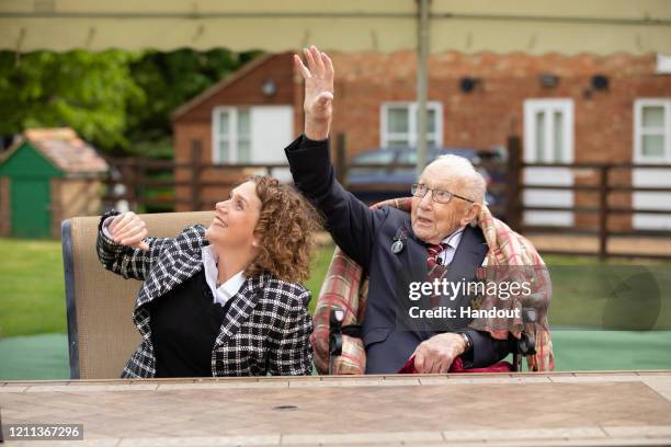 In this handout image provided by Capture the Light Photography, Colonel Tom Moore and his daughter Hannah celebrate his 100th birthday, with an RAF...