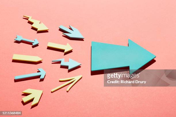 a group of small arrows propelling a big arrow - ziel stock-fotos und bilder