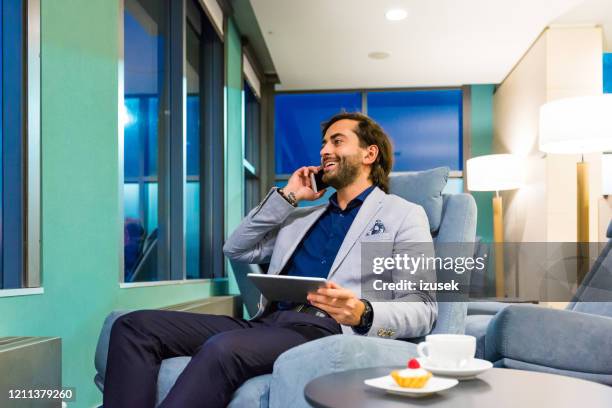 businessman sitting in the aiport vip lounge at night - star style lounge imagens e fotografias de stock